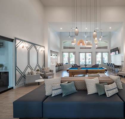 a large living room with a pool table and couches