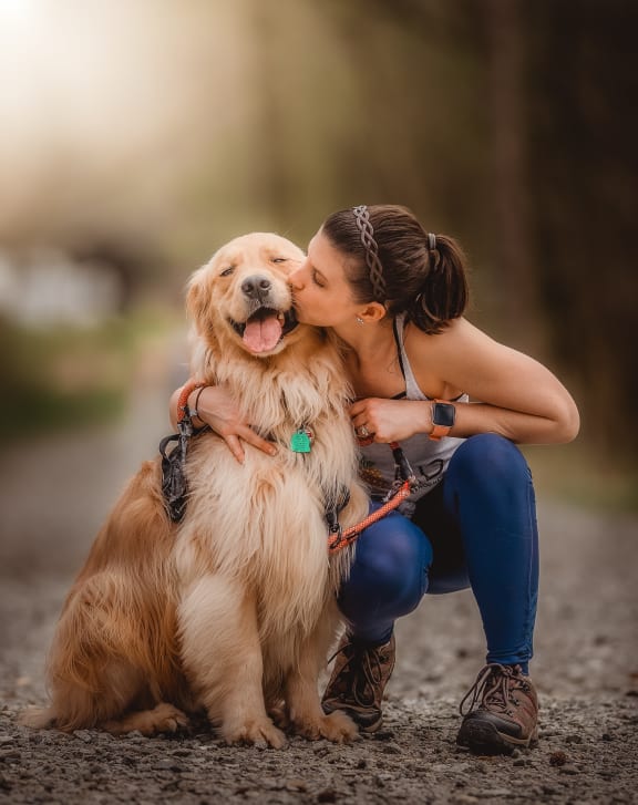 a woman kissing her dog on the head