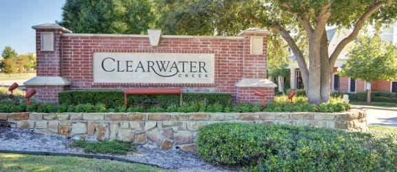 a sign for clearwater college in front of a brick wall