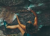 Thumbnail 10 of 16 - A woman climbing a rock at Red Rock Apartments, South Dakota, 57702