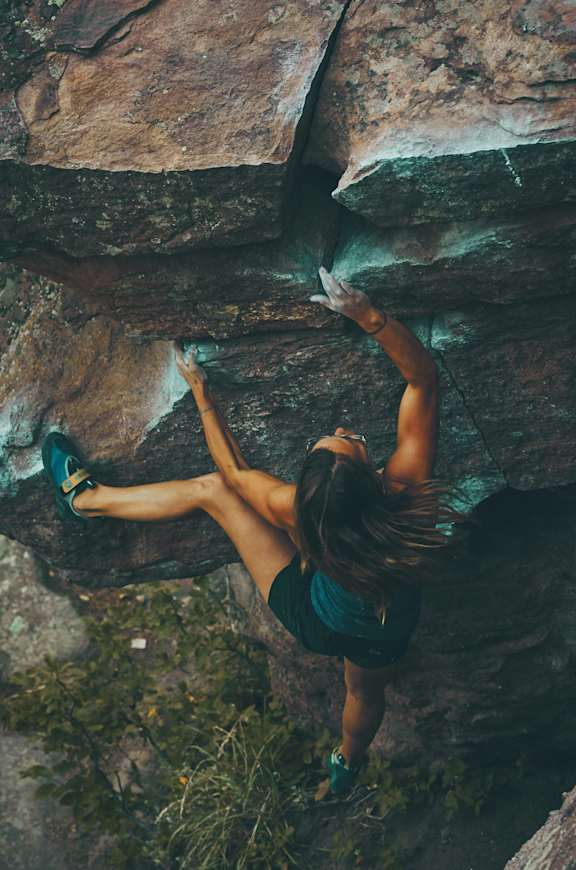 A woman climbing a rock at Red Rock Apartments, South Dakota, 57702