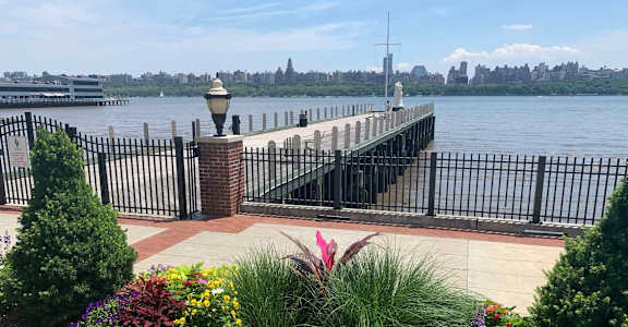 A view of a pier with a lamp post and a fence.