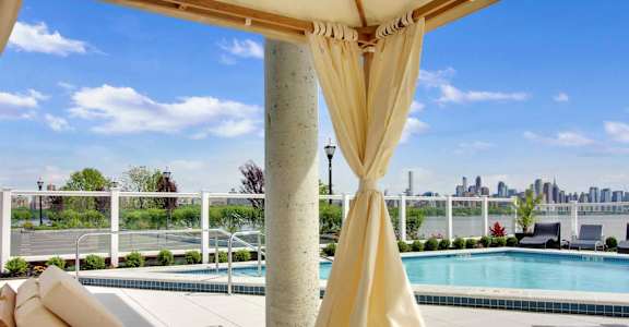 A pool area with a view of the city skyline.