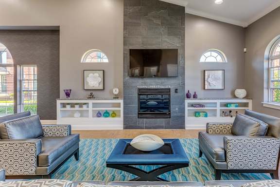 A living room with a fireplace and a blue rug.