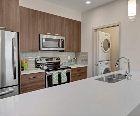 A kitchen with white appliances and counters at Escape. 