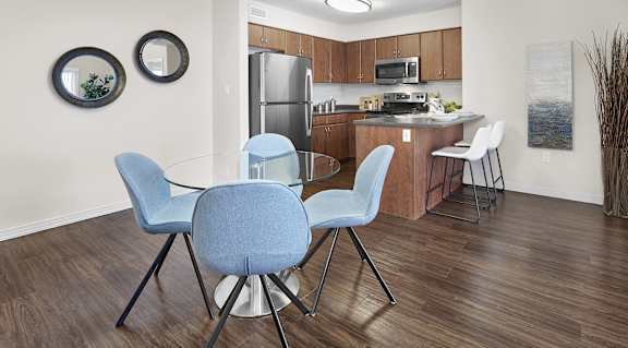 A kitchen with a table and chairs.