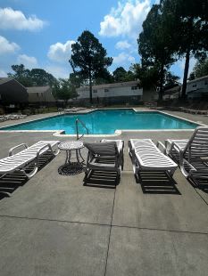 A pool with a table and chairs around it.