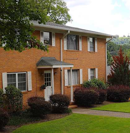 a large brick house with a yard in front of it