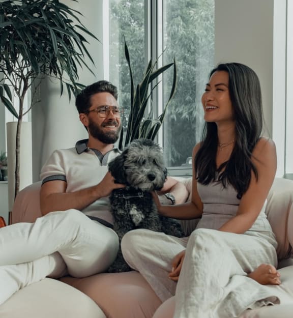 a man and a woman sitting on a couch with a dog