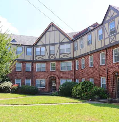 a large brick building with a yard in front of it