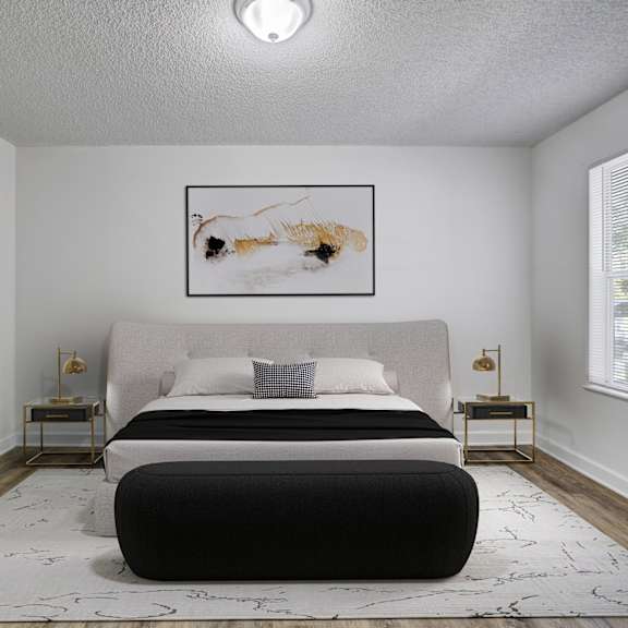 A bedroom with a large bed and a painting on the wall.