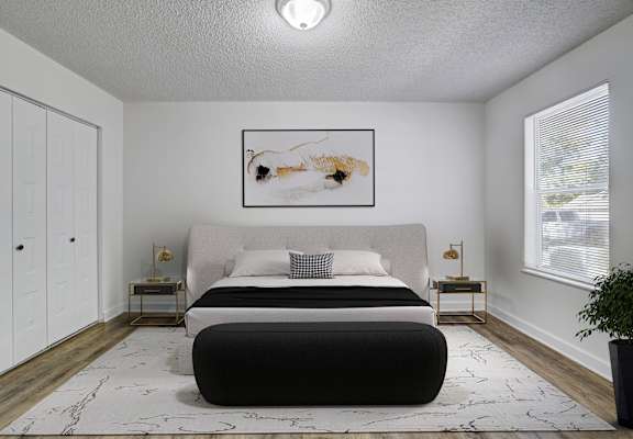 A bedroom with a large bed and a painting on the wall.