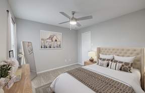 the master bedroom has a comfy bed and a ceiling fan