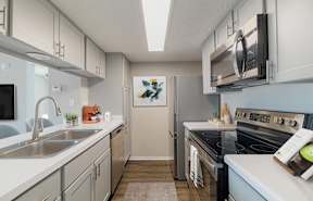 a kitchen with white cabinets and black appliances and a sink