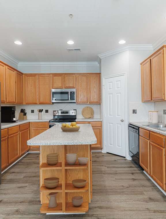 A kitchen with wooden cabinets and a refrigerator.