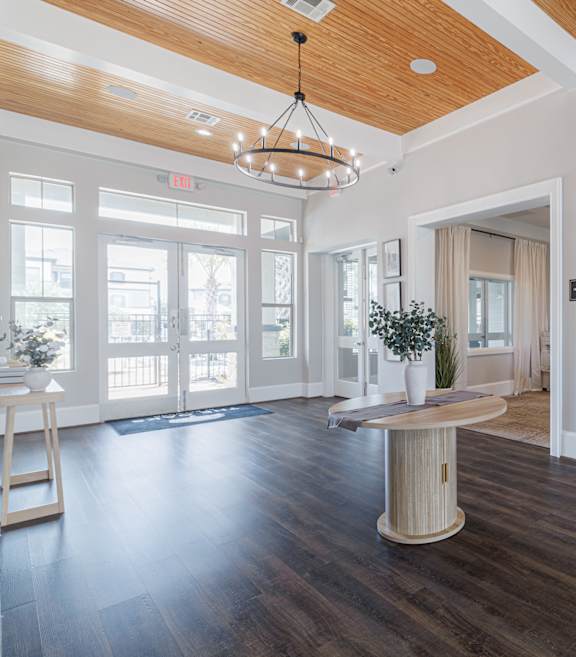 A large room with a wooden floor and a high ceiling with a chandelier.