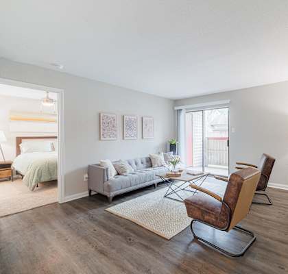 A living room with a grey couch and a brown chair.