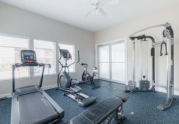 A spacious home gym with a treadmill, elliptical trainer, and other exercise equipment.