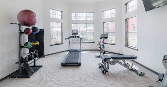 A spacious home gym with a variety of exercise equipment.