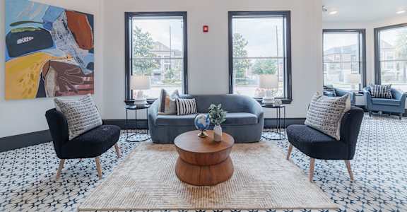 A living room with a large painting on the wall and a coffee table in the center.