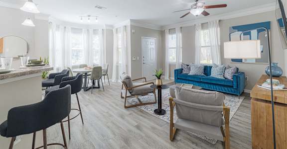 A living room with a blue couch and a wooden floor.