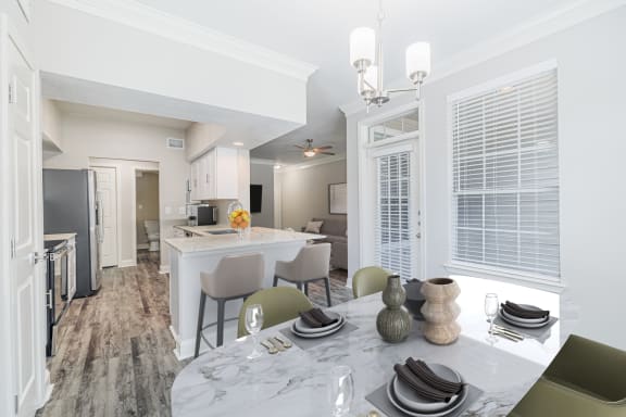 a dining room and kitchen area with a table and chairs