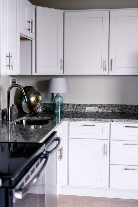 A kitchen with white cabinets and a black stove top at Hampton Plaza Apartments, Towson, MD, 21286