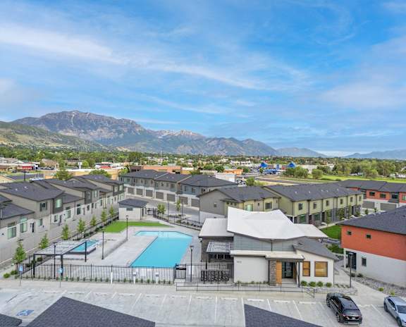 A view of a resort with a swimming pool and a mountain in the background.