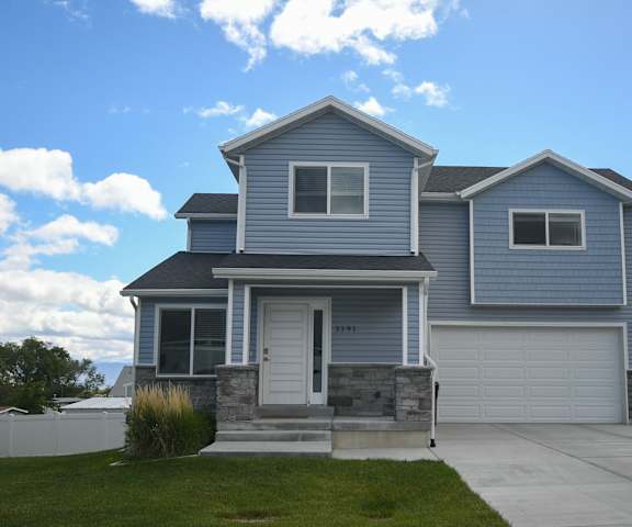 a blue house with a driveway and a white garage door