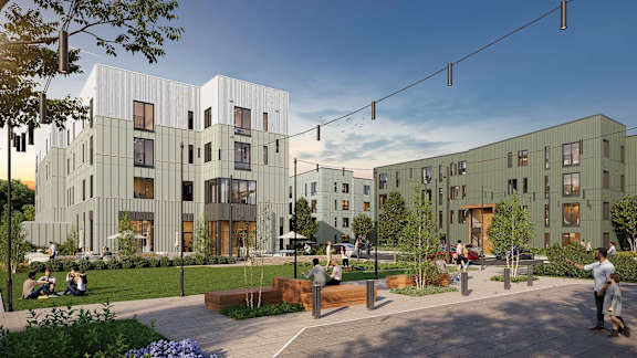 A modern building complex with a courtyard and people sitting and walking around.