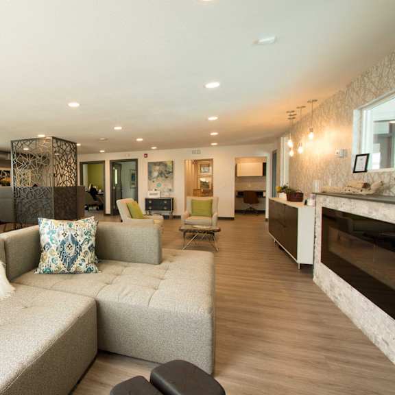 an open concept living room and dining area with a white dining table and rattan chairs