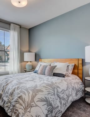 a bedroom with a bed and a large window