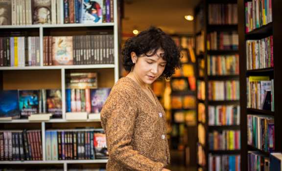 a woman looking at books in a bookstore  at Residences at Westborough Station, Westborough, 01581