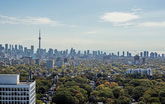 A cityscape with a tall tower in the background and a building in the foreground.
