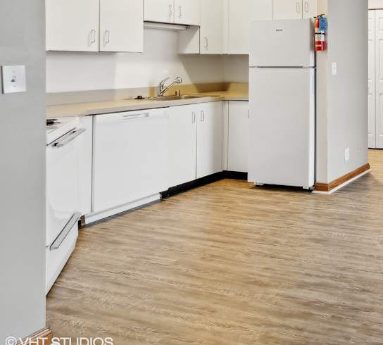a spacious living room with a kitchen and a large window at Delmar Loop Apartments, St. Louis, MO, 63112