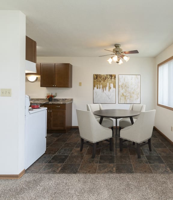 a dining room with a table and chairs and a kitchen