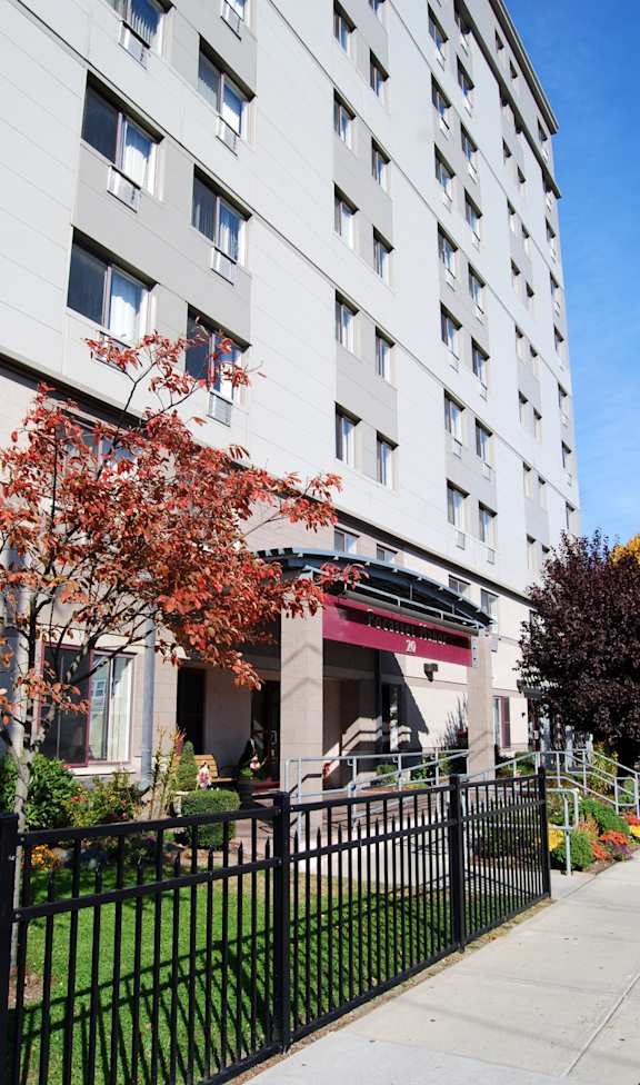 A tall white building with a black fence in front of it.