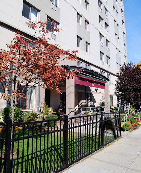 A tall white building with a black fence in front of it.