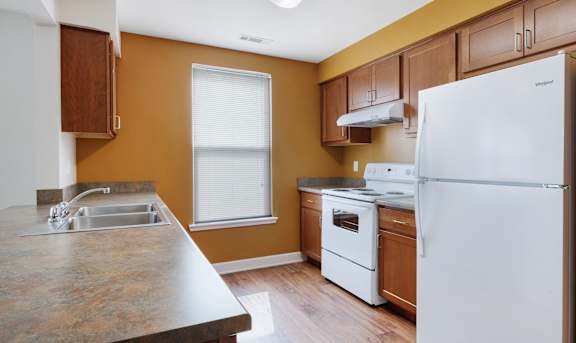 a kitchen with white appliances and wooden cabinets