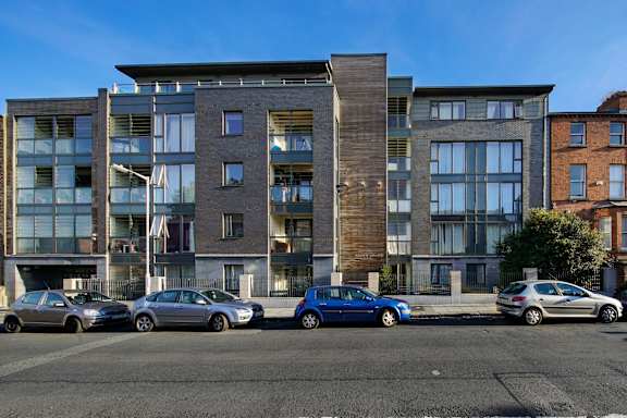 a view of a building with cars parked in front of it