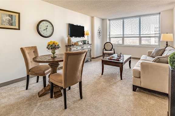 A living room with a sofa, chairs, and a television.