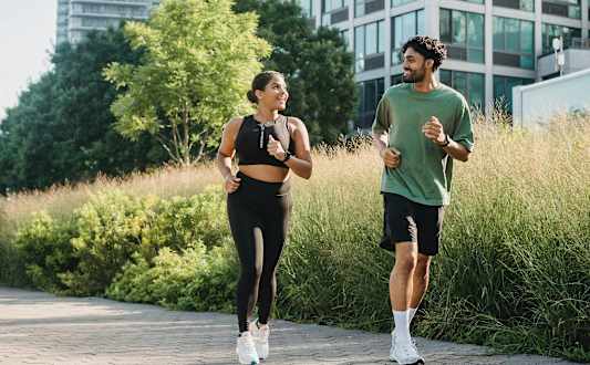 Two people jogging in a city park.