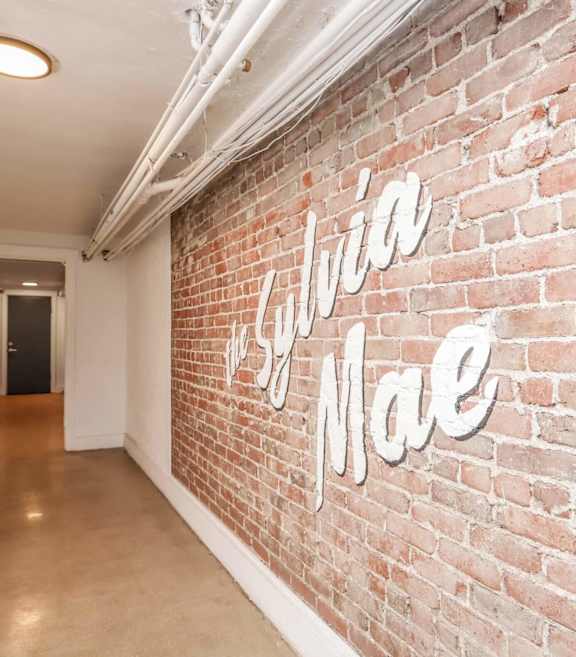 A hallway with a brick wall and a sign that says 
