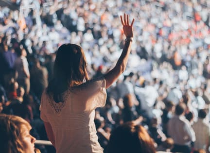 a woman in a crowd of people with her hand up in front of a audience at 44 Washington, Kansas City, MO