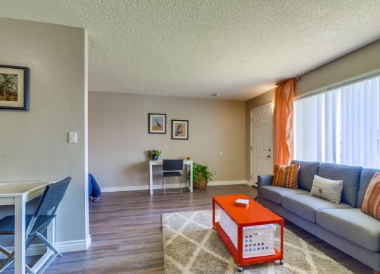 Beige and Grey Walls, Plank Flooring, Large Window, and Popcorn Ceiling at Las Brisas Apartments, Colton