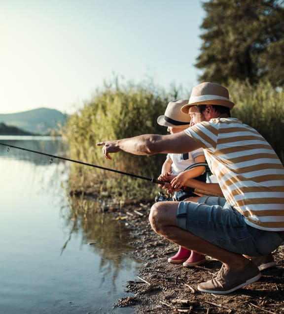a man and a child fishing on a lake at Colony Townhomes, Raleigh, NC, 27609
