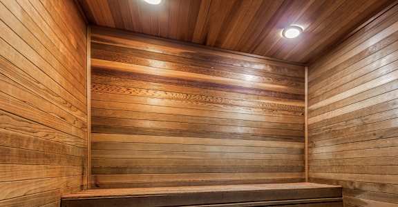 A wooden sauna with benches and a sign on the wall.