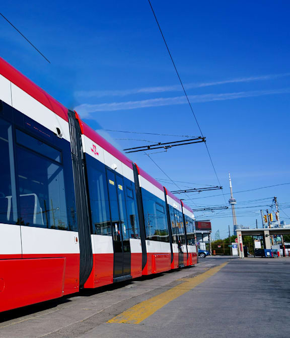A red and white train is parked on the tracks.