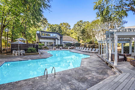 A living room with a wooden table and white couches. at Madison Southpark Apartment Homes, Charlotte, NC, 28226