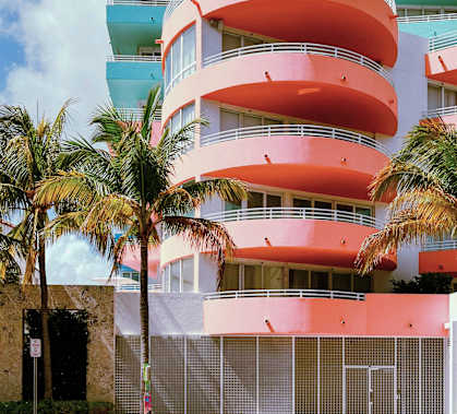 A multi-story building with a pink and blue exterior.